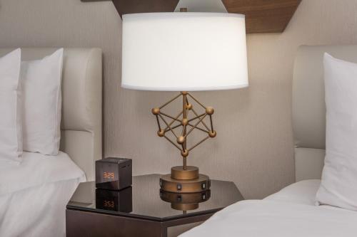 a lamp on a table next to two beds at Le Meridien Boston Cambridge in Cambridge