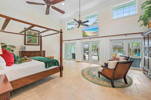 a bedroom with a bed and a chair and windows at KonTiki Falls! Jupiter's Exclusive Private Resort in Jupiter