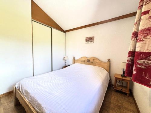 une chambre avec un lit blanc dans une pièce dans l'établissement Résidence Les Balcons Du Charvin - Au coeur de l'Espace Diamant, à côté de l'aire de loisirs et de l'arrêt de ski-bus MAE-3064, à Notre-Dame-de-Bellecombe