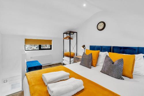 a bedroom with a white bed with yellow and blue pillows at On the Water 5 A One-of-a-Kind Stay Free Parking By My Getaways in Brighton & Hove