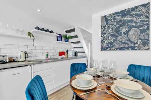 a kitchen with a wooden table and blue chairs at On the Water 5 A One-of-a-Kind Stay Free Parking By My Getaways in Brighton & Hove