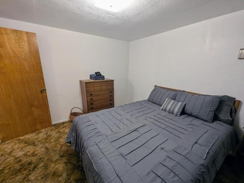a bedroom with a large bed and a wooden dresser at Meadow View Cabin in Wilsonia in Wilsonia
