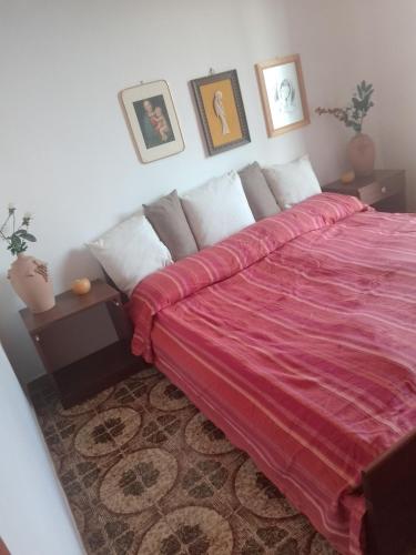 a bedroom with a large bed with a red blanket at Villa Angela in Quasani