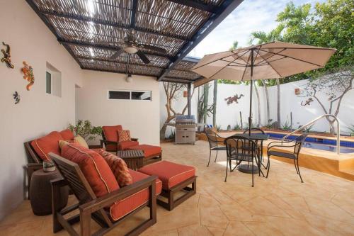 a patio with a table and chairs and an umbrella at Casa de los Geckos in La Paz