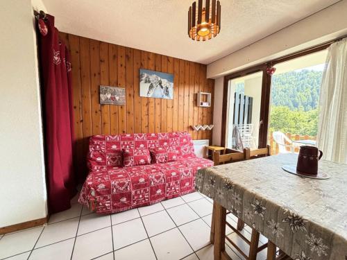 un salon avec un canapé rouge et une table dans l'établissement Résidence Les Balcons Du Charvin - Appartement exposé sud avec vue nature MAE-3234, à Notre-Dame-de-Bellecombe