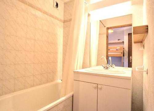 une salle de bain avec un lavabo, un miroir et une baignoire dans l'établissement Résidence Les Balcons Du Charvin - Appartement exposé sud avec vue nature MAE-3234, à Notre-Dame-de-Bellecombe