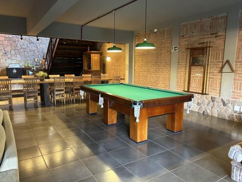 a pool table in a room with tables and chairs at Hotel Villa D'Angelo in Itatiba