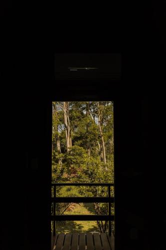 an open door with a view of a forest at Chalé Eucalipto in Uberlândia