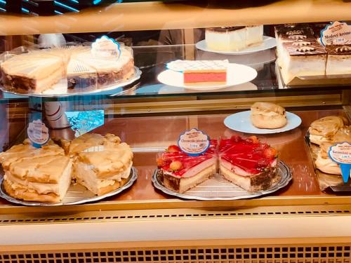 a display case filled with different types of cakes at Apartmán Strečno v centre s výhľadom na Lomnický štít in Vysoké Tatry