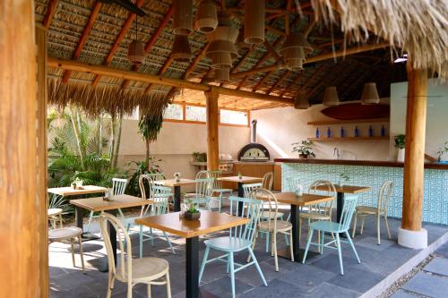 a restaurant with tables and chairs and a bar at Bidmont Villa & Spa - Luxury Wellness Retreat in Puerto Escondido