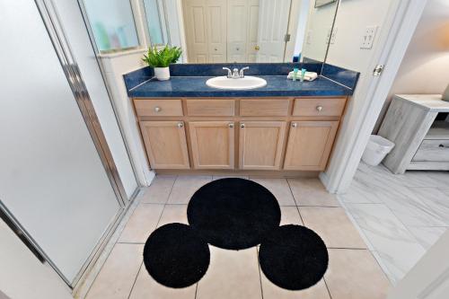 a bathroom with a sink and a black rug on the floor at Star Oasis At Citrus Ridge By Shine Villas 091 in Orlando
