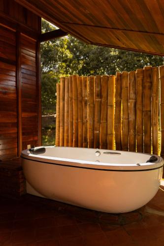 a bath tub sitting in a room with a window at Chalé Eucalipto in Uberlândia