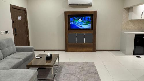a living room with a couch and a tv at Golden Season Hotel - Al-Rass - فندق جولدن سيزون - الرس in Al Rass