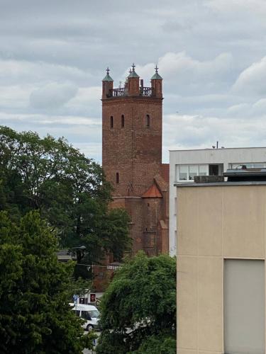 una torre di mattoni alta con torrette in cima a un edificio di STARY RYNEK Apartament Centrum a Słupsk