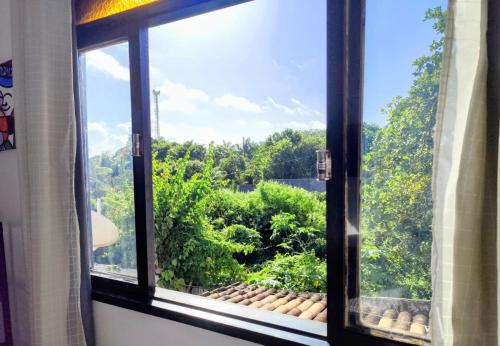 a window with a view of a forest at Pipa Universo in Pipa