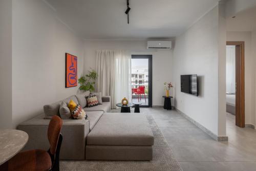 a living room with a couch and a table at Livingville East Aparthotel in Cairo