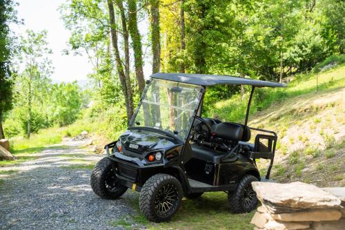a black golf cart parked on a dirt road at Les Granges du Hautacam in Artalens-Souin