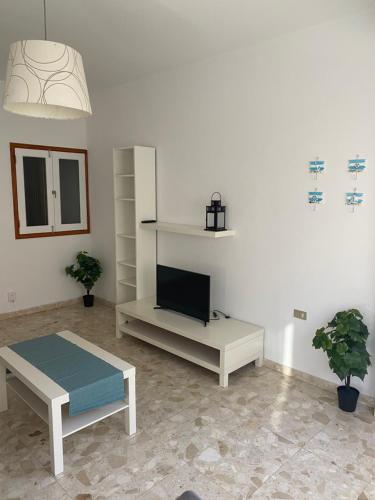 a living room with a tv and a couch and a table at Estocolmo Lovely in Gran Tarajal