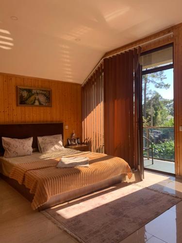 a bedroom with a large bed and a large window at KOTEJ UREKI in Ureki