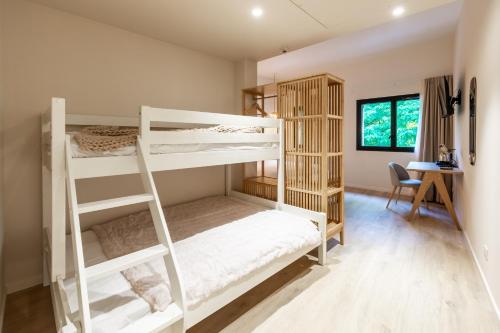 a bedroom with two bunk beds and a desk at Hôtel La Cachette de Nina- Madame rêve - Saint-Girons in Saint-Girons