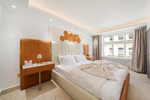 a bedroom with a bed and a desk and a window at Prime Mayfair Luxury Stunning 2 Bedroom Apartment H12 in London