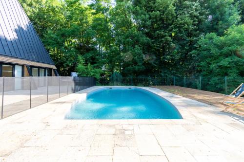 a swimming pool in a yard next to a house at Hôtel La Cachette de Nina- Madame rêve - Saint-Girons in Saint-Girons