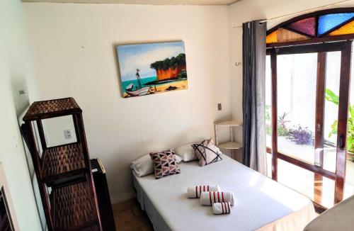 a small bedroom with a bed and a window at Pipa Universo in Pipa
