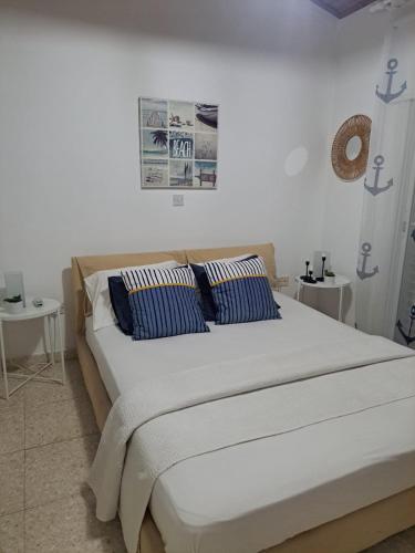 a large bed with blue pillows in a bedroom at Seafront Beach House in Meneou