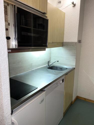 une cuisine avec un évier et un micro-ondes dans l'établissement Résidence Soldanelles Villages - Studio divisible 4 personnes - Plagne Village MAE-4824, à La Plagne Tarentaise