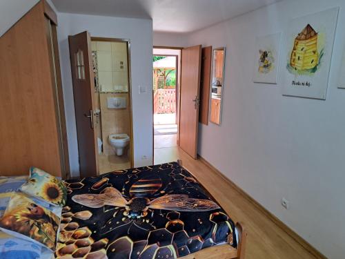 a bedroom with a bed with a comforter on it at Domek Miodu mi daj in Wisła