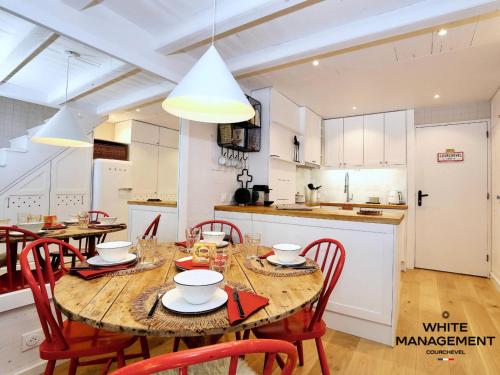 une cuisine et une salle à manger avec une table et des chaises en bois dans l'établissement Résidence Solaret Des Brigues - Superbe duplex dans le quartier des Brigues MAE-5864, à Courchevel
