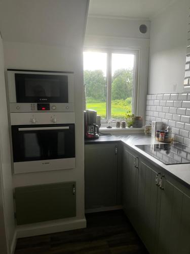 a kitchen with a microwave oven and a window at Kulla Skola in Veddige
