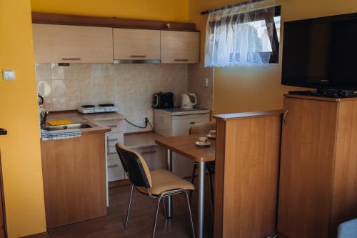 a small kitchen with a small table and a television at Rekreační a školicí středisko Zájezek in Chlum u Třeboně