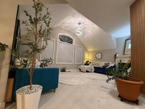 a living room with a blue couch and potted plants at Luxurious Villa 3 Living Rooms, 1 sofa bed, 4 bedrooms, 4 Beds, 4 Toilets, 1 hour To Toronto in Oshawa