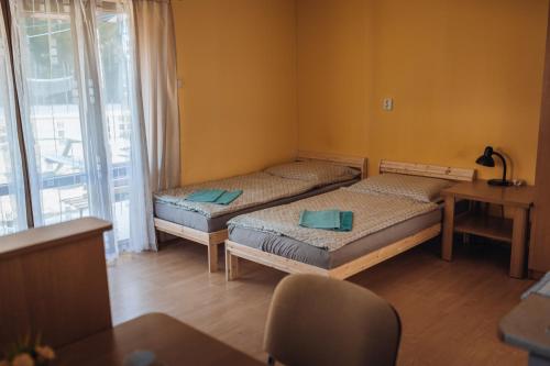 two beds in a room with a table and a chair at Rekreační a školicí středisko Zájezek in Chlum u Třeboně