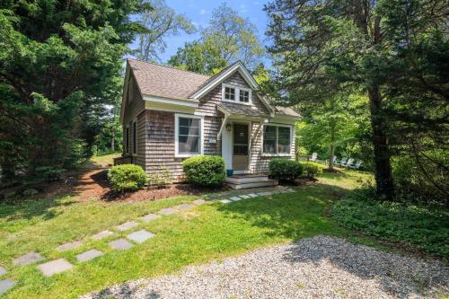 a small house in a yard with trees at Walk to Beach Close to Town in Orleans