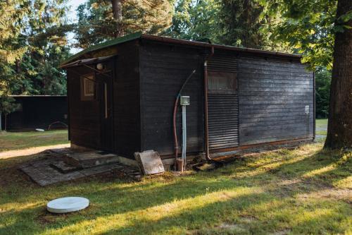 a small wooden shed in a field with a frisbee at Rekreační a školicí středisko Zájezek in Chlum u Třeboně