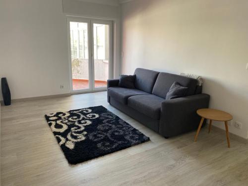 a living room with a blue couch and a rug at Casa Os Três Meninos in Fátima