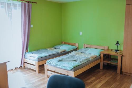 two beds in a room with green walls at Rekreační a školicí středisko Zájezek in Chlum u Třeboně