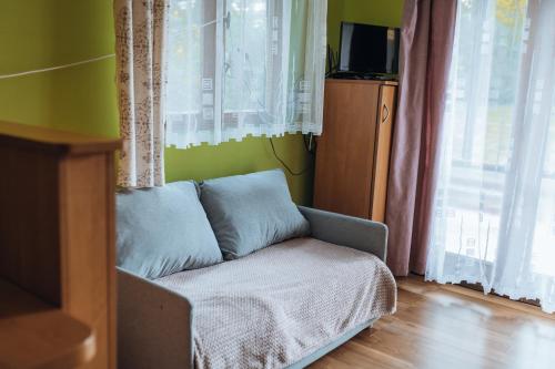 a living room with a couch in a room with windows at Rekreační a školicí středisko Zájezek in Chlum u Třeboně