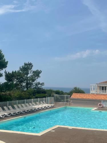 une grande piscine avec des chaises longues dans l'établissement Appartement T2 plein sud aux Sables d'Olonne, à Les Sables-dʼOlonne