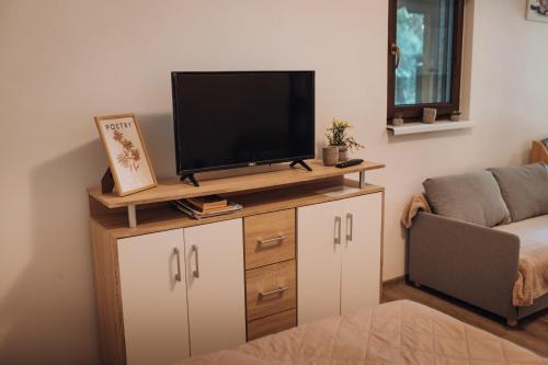 a living room with a flat screen tv on a cabinet at Rekreační a školicí středisko Zájezek in Chlum u Třeboně