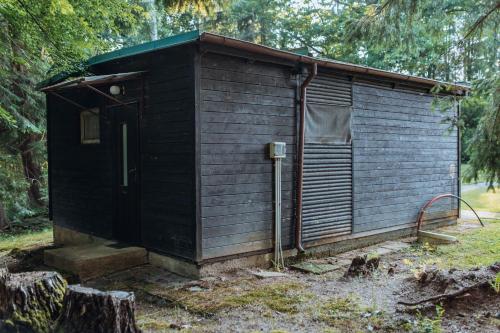 a small wooden building with a door in the grass at Rekreační a školicí středisko Zájezek in Chlum u Třeboně