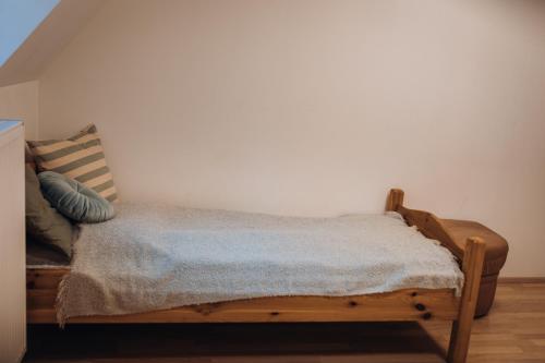 a wooden bed in a room with a white wall at Rekreační a školicí středisko Zájezek in Chlum u Třeboně