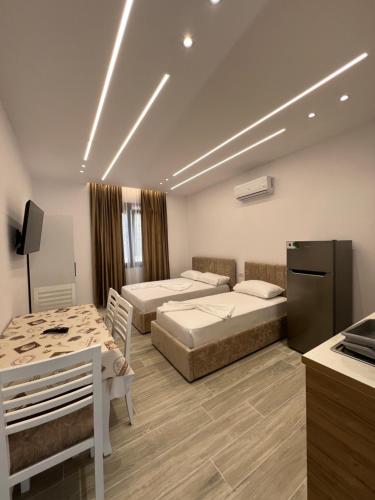 a hotel room with two beds and a refrigerator at Niks apartments in Vlorë