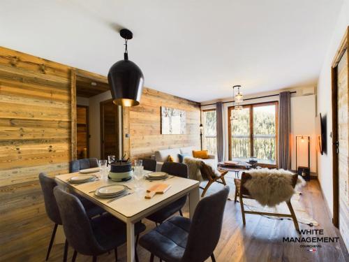 une salle à manger avec une table et des chaises dans l'établissement Résidence Ariondaz Heliantheme - Superbe 3 pièces cabine proche des pistes MAE-4824, à Courchevel