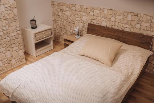 a bedroom with a bed and a stone wall at Rekreační a školicí středisko Zájezek in Chlum u Třeboně