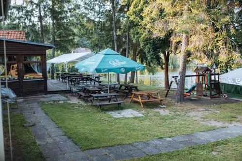 a group of picnic tables with umbrellas and a playground at Rekreační a školicí středisko Zájezek in Chlum u Třeboně