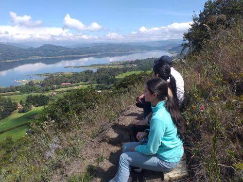 a group of people sitting on a hill overlooking a lake at Casa Quinta Mozart in Guatavita