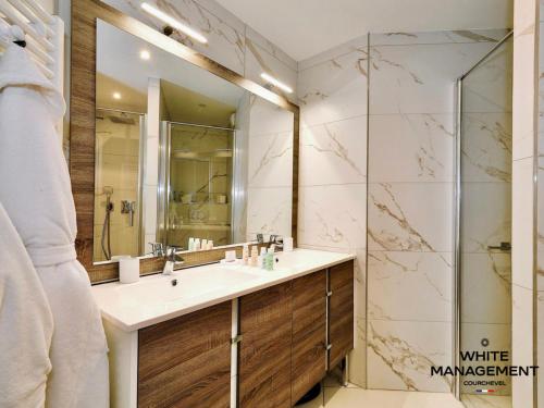 une salle de bain avec un lavabo et une douche dans l'établissement Résidence Ariondaz Hellebore - Superbe appartement haut de gamme et ski-in MAE-4714, à Courchevel